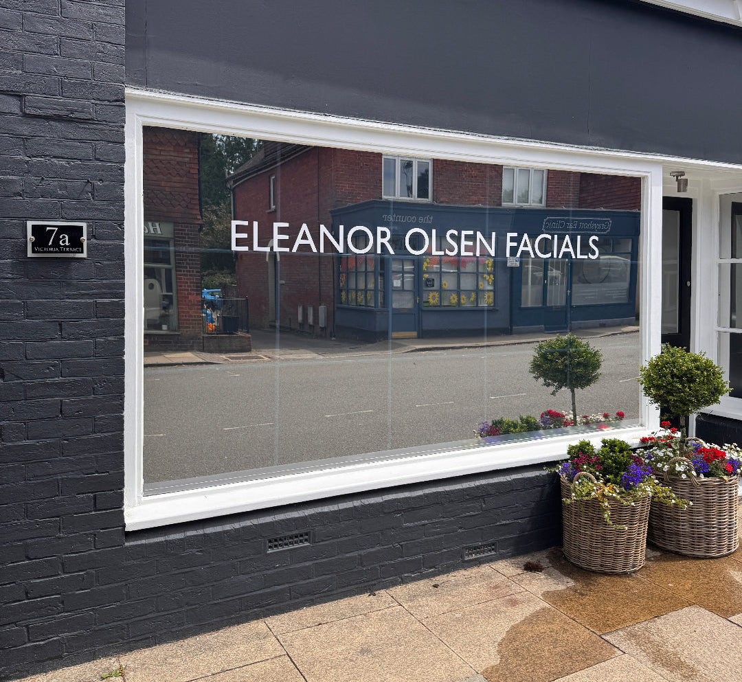 Storefront with 'Eleanor Olsen Facials' sign on a clear day.